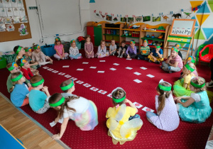 Dzieci siedzą w kole na dywanie