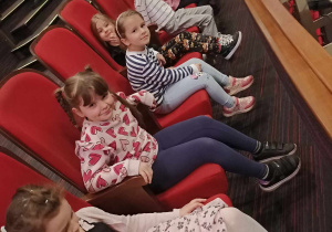 Grupa dzieci siedzi na widowni.