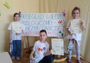 Troje dzieci pokazuje dyplomy za udział w konkursie