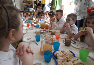 Dzieci jedzą przy wspólnym stole