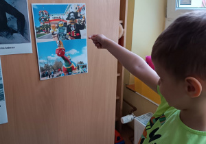 Chłopiec pokazuje ilustrację z klockami lego - marzeniem wszystkich dzieci