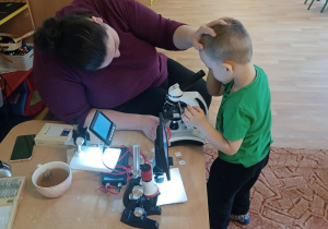 Chłopiec patrzy przez mikroskop
