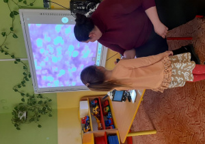 Dzieci obserwują powiększone obrazy mikroskopowe
