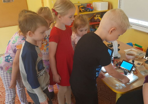 Dzieci podkładają pod mikroskop różne preparaty
