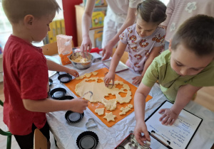 Dzieci wykrawają caisto przy pomocy foremek