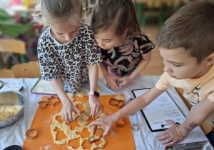 Dzieci wykrawają ciasto przy pomocy foremek