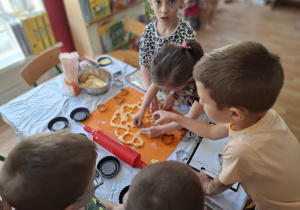 Dzieci wykrawają ciasto przy pomocy foremek