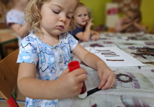 Dziewczynka wykonuje pracę plastyczną