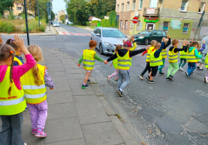 Dzieci przechodzą przez ulicę na przejściu dla pieszych