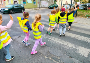 Dzieci przechodzą przez ulicę na przejściu dla pieszych