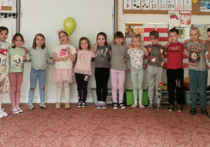 Grupa dzieci pozuje do zdjęcia z jubilatką