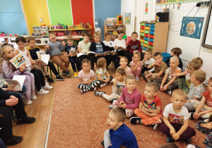 Uczniowie szkoły podstawowej czytają przedszkolakom swoje ulubione książki