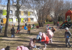Dzieci porządkują ogród przedszkolny
