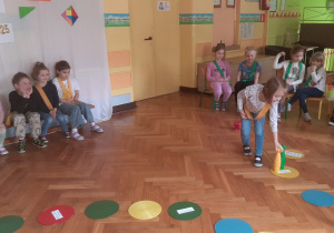 Dziewczynka stawia żółty kręgiel na planszy