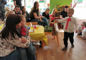 Chłopiec idzie w stronę swojej mamy z wielkanocnymi prezentami.