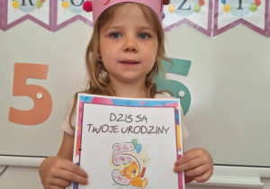 Solenizantka stoi i trzyma dyplom