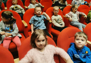 Dzieci siedzą na widowni czekając na rozpoczęcie spektaklu