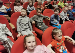 Dzieci siedzą na widowni czekając na rozpoczęcie spektaklu