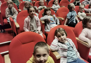 Dzieci siedzą na widowni czekając na rozpoczęcie spektaklu