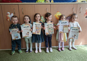 Dzieci z grupy pierwszej pozują do zdjęcia trzymając dyplomy i nagrody za udział w konkursie