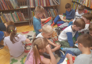 Dzieci oglądają książki w bibliotece