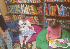 Dzieci oglądają książki w bibliotece