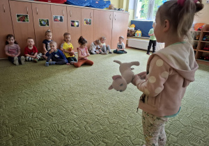 Dziewczynka recytuje wiersz dzieciom ze swojej grupy