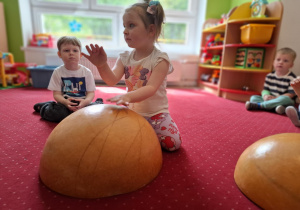 Dziewczynka gra na instrumencie wykonanym z wydrążonej dyni