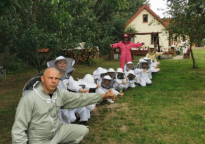 Dzieci pozują w pszczelarskich kombinezonach do zdjęcia