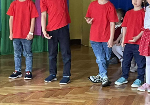 Grupa dzieci stoi i śpiewa piosenkę
