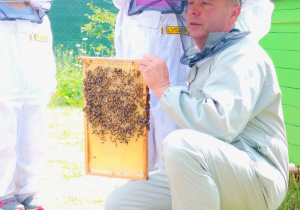 Dzieci pozują do zdjęcia z plastrem miodu