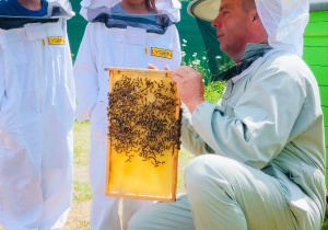 Dzieci pozują do zdjęcia z plastrem miodu