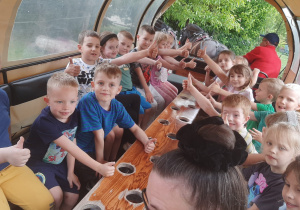 Dzieci pozują do zdjęcia w bryczce