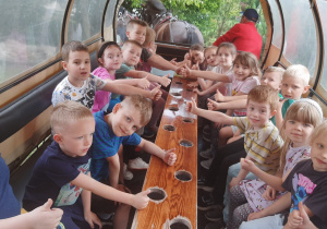 Dzieci pozują do zdjęcia w bryczce