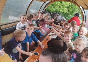 Dzieci pozują do zdjęcia w bryczce