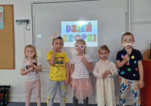 Czworo dzieci trzyma w ręku maskę na patyku zrobioną przez siebie