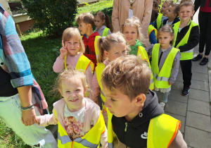 Grupa dzieci idzie parami po chodniku
