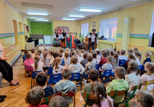 Dzieci ze wszystkich grup oglądają występ tancerzy w strojach ludowych