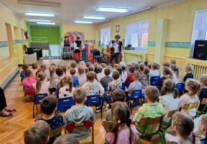 Dzieci ze wszystkich grup oglądają występ tancerzy w strojach ludowych