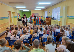 Dzieci ze wszystkich grup oglądają występ tancerzy w strojach ludowych