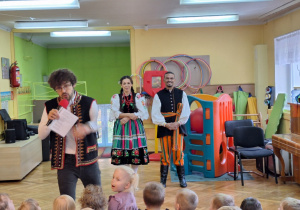 Dzieci ze wszystkich grup oglądają występ tancerzy w strojach ludowych
