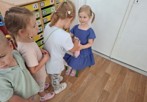 Dziewczynka częstuje dzieci cukierkami