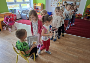 Chłopiec częstuje dzieci cukierkami