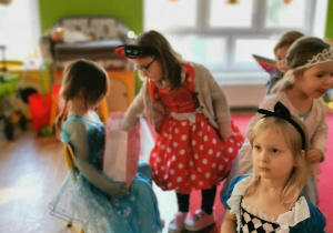 Dziewczynka częstuje dzieci cukierkami