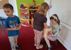 Dziewczynka częstuje dzieci cukierkami