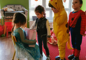 Dziewczynka częstuje dzieci cukierkami