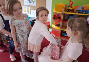 Dziewczynka częstuje dzieci cukierkami