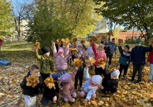 grupa dzieci z bukietami z liści
