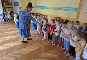 Nauczycielka z pierwszej grupy pasuje nowe dzieci na przedszkolaki