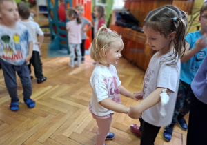 Dwie dziewczynki tańczą wspólnie trzymając się za ręce